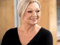 Uśmiechnięta Małgorzata Walewska, której wiek dodaje jej uroku, w czarnej bluzce.