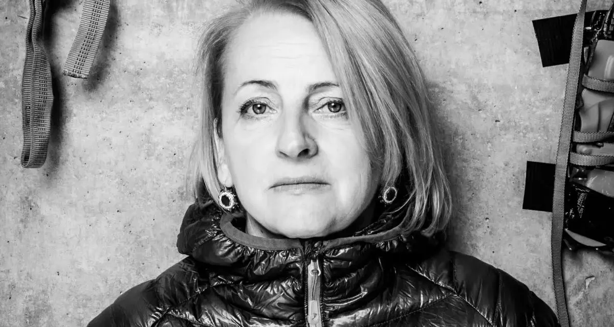 Portret Ewy Berbeki w czarno-białej tonacji, na tle betonowej ściany z elementami wspinaczkowymi.