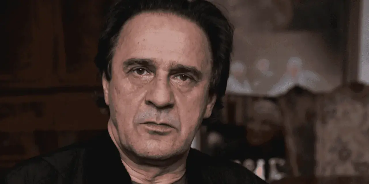 Bronisław Wrocławski, zamyślony, w tle niewyraźne sylwetki dzieci.