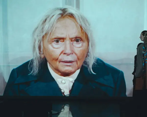 Patrycja Szwarc, aktorka, na ekranie w zbliżeniu. Obok stoi młoda kobieta.