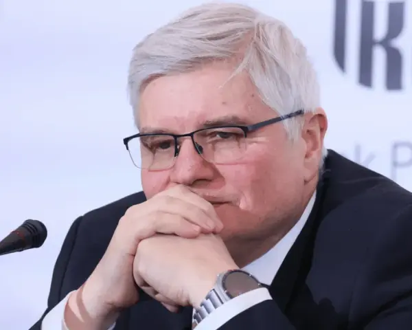 Tadeusz Kalinowski, zamyślony, z dłońmi przy ustach, jakby rozmawiał o przyszłości swoich dzieci.