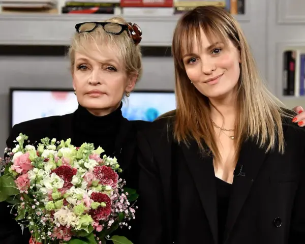 Joanna Biedrzyńska z córką, obie ubrane na czarno, z bukietem kwiatów.