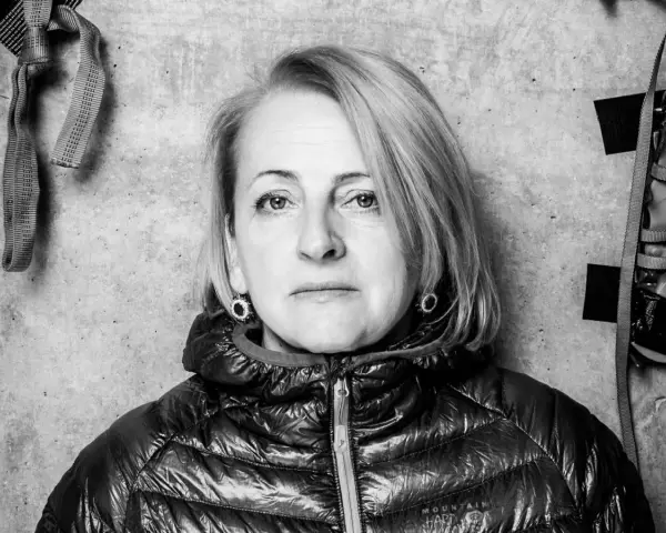 Portret Ewy Berbeki w czarno-białej tonacji, na tle betonowej ściany z elementami wspinaczkowymi.