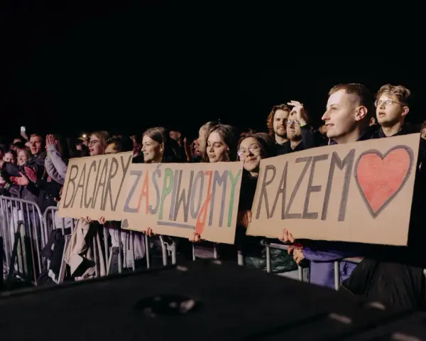 Fani trzymają transparent: "Baciary zaśpiewajmy razem" z sercem.