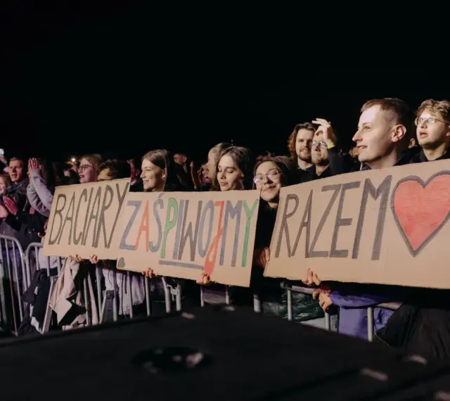 Fani trzymają transparent: "Baciary zaśpiewajmy razem" z sercem.